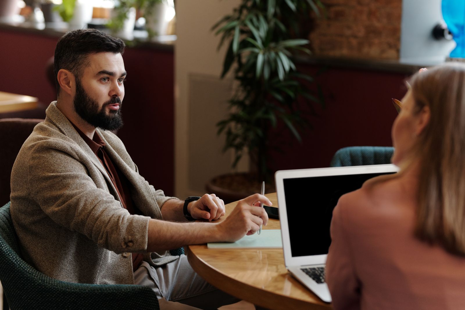 Independent agent reviewing a business owner's policy quote on a laptop in a café