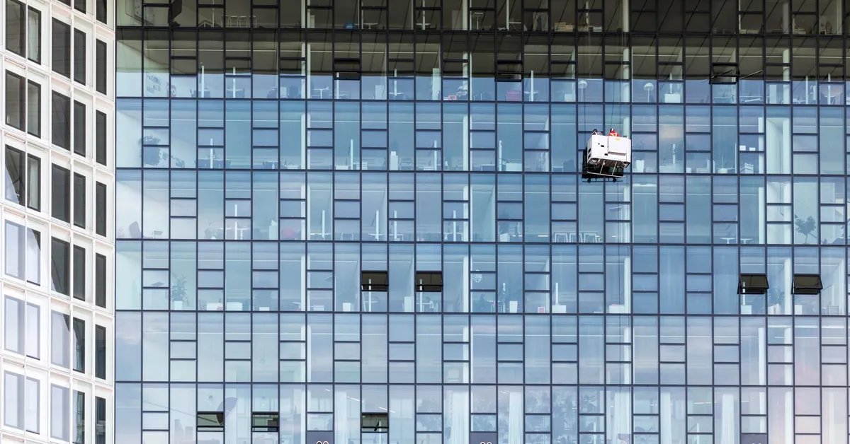 High-rise glass building exterior with window cleaners in Hamburg, Germany. modern office building with window cleaners in hamburg