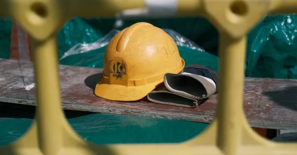 Close-up of a yellow construction helmet on a workbench at a building site. yellow construction helmet on industrial site