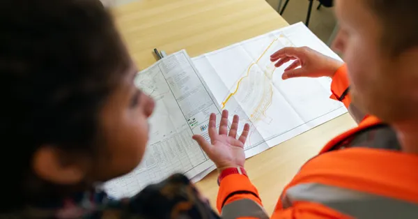 Two engineers reviewing construction blueprints on a table in an office setting. civil engineer planning dam