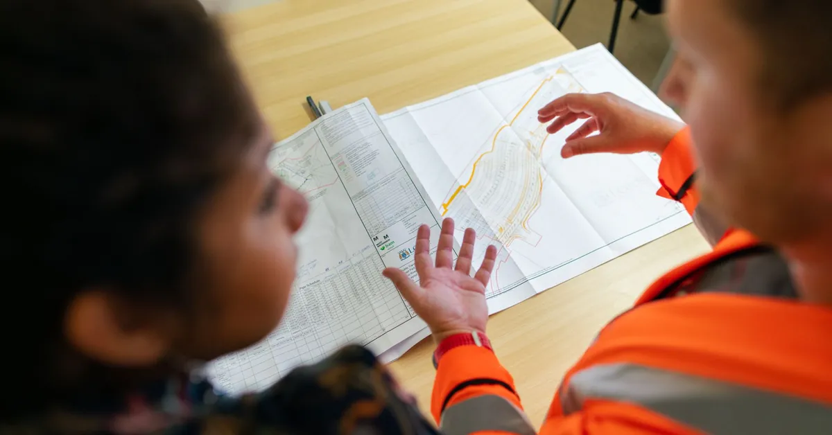 Two engineers reviewing construction blueprints on a table in an office setting. civil engineer planning dam