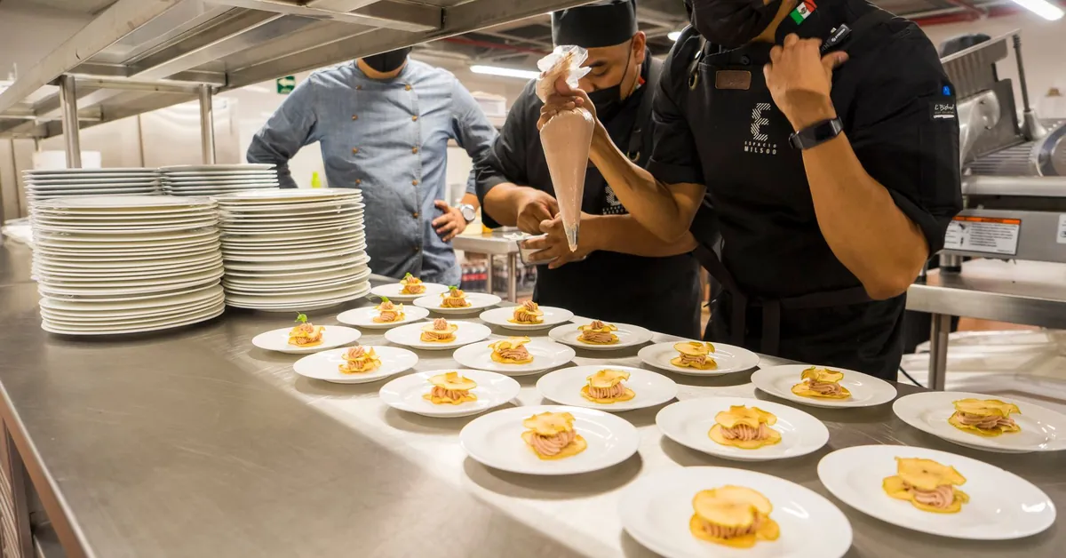 Team of chefs creatively plating gourmet appetizers in a commercial kitchen. food on plates in kitchen