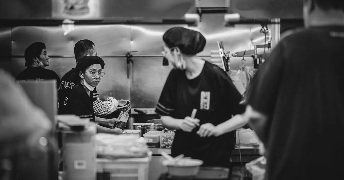 Dynamic scene of chefs working in a restaurant kitchen, captured in black and white. busy restaurant kitchen in black and white