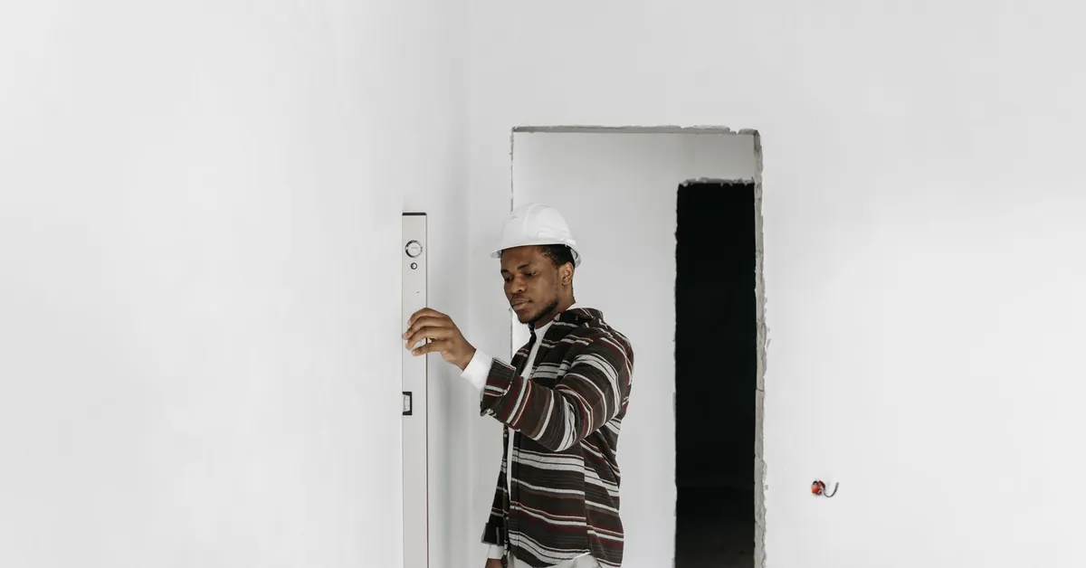 Architect wearing hard hat checks wall alignment in a renovation project. an architect wearing hard hat checking the walls of the house