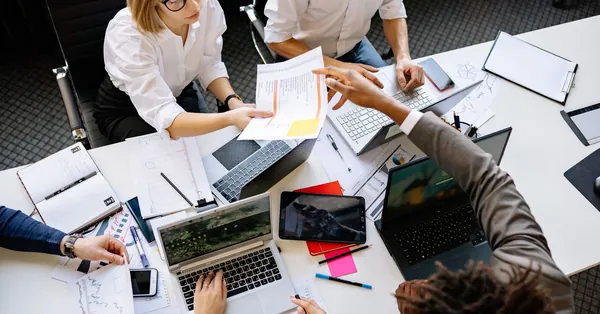 Diverse team collaborating in a modern office with laptops and documents. colleagues working in an office
