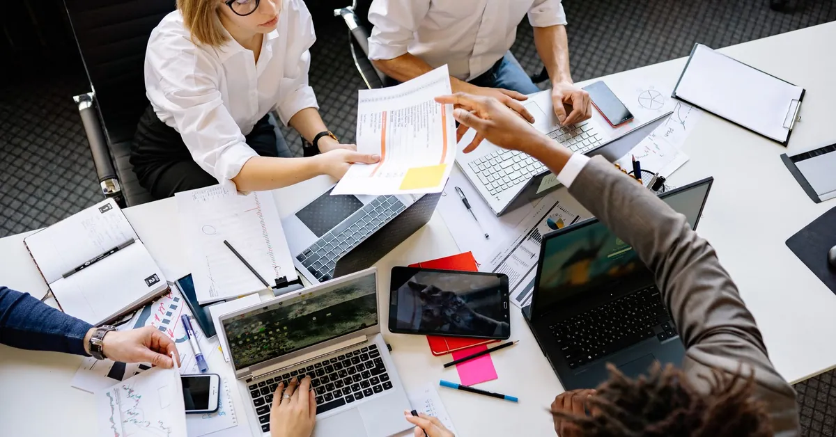 Diverse team collaborating in a modern office with laptops and documents. colleagues working in an office