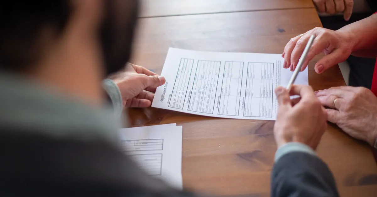 Close-up of business professionals reviewing documents at a meeting. an agent handing a pen to a client