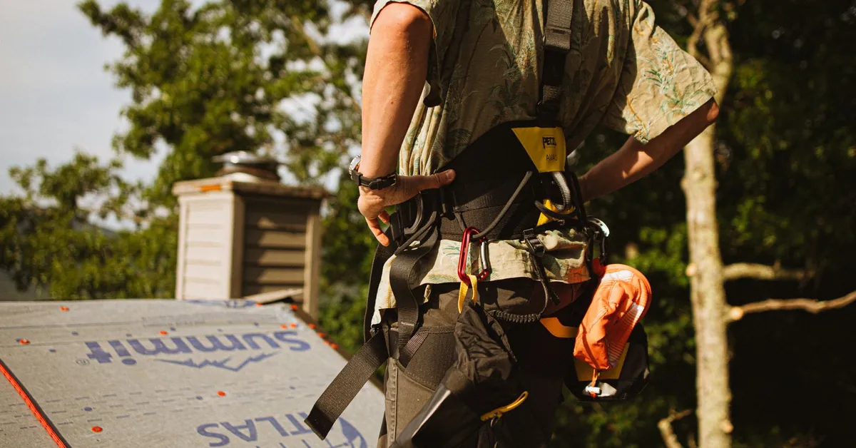 Construction worker wearing safety harness on a rooftop in North Carolina. roofer at work with safety gear in north carolina