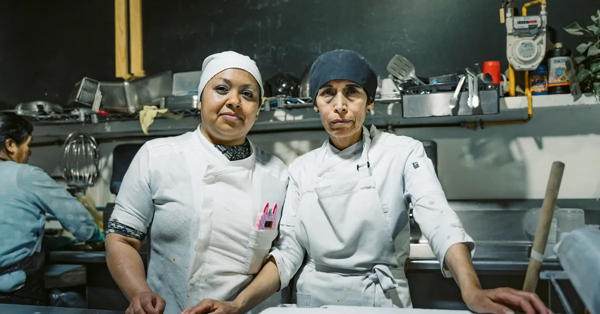 Two skilled chefs in a Mexican restaurant kitchen, showcasing teamwork and culinary expertise. women in kitchen